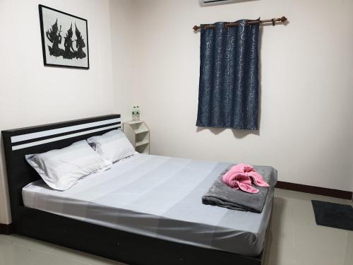 a bedroom with a bed with a pink stuffed animal on it at TP home in Bangkok