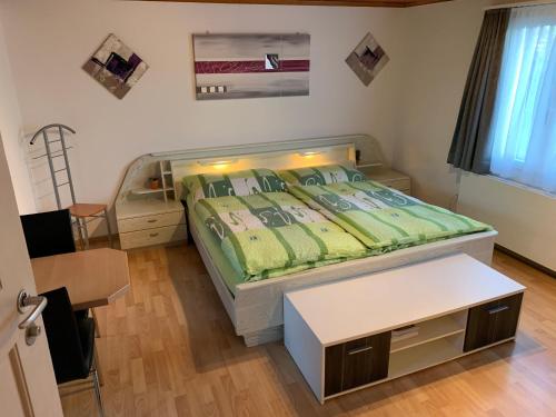 Dormitorio pequeño con cama y mesa en El's Guesthouse, en Bannwil