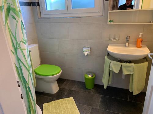 baño con aseo verde y lavamanos en El's Guesthouse, en Bannwil