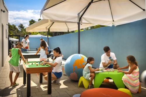 a group of people playing a game with a table at Valamar Camping Padova in Rab