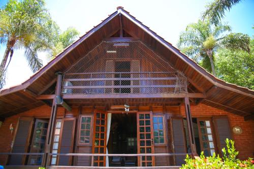 a wooden house with a balcony on top of it at Casa de Campo Magnifica in Piracicaba