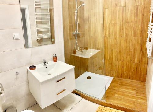 La salle de bains est pourvue d'un lavabo blanc et d'une douche. dans l'établissement Fort Wola 12B by Homeprime, à Varsovie