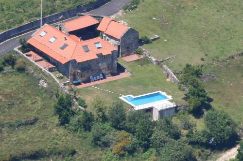 una vista aérea de una casa con piscina en Rectoral de Prado, en Piñeiro