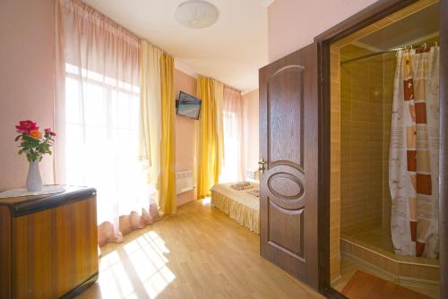 a bedroom with a bed and a shower in a room at Altera Guest House in Popovka