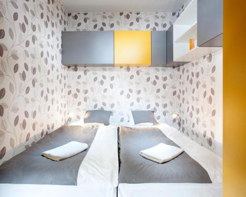 1 dormitorio con 2 camas y pared cubierta de papel pintado en Yellow apartment Deluxe, en Brno