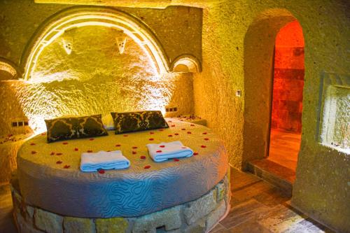 een slaapkamer met een groot bed in een stenen kamer bij Cappadocia Cave House in Urgup