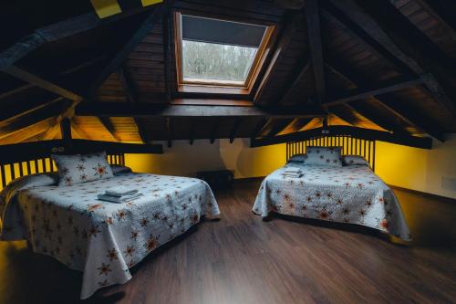 een kamer met 2 bedden en een raam bij El Reinazu in Cangas de Onís