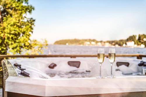 two glasses of champagne on a table next to the water at Hotell Furusund in Furusund