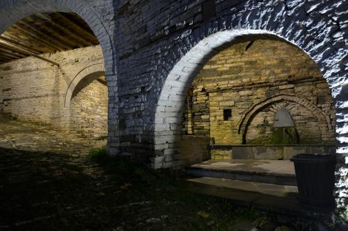 an old brick building with arches and a statue in it at Nikolas Guesthouse in Koukouli