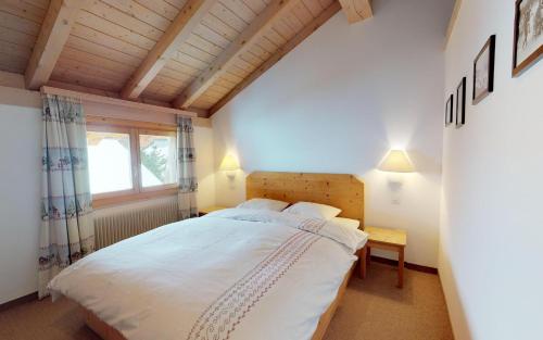 a bedroom with a large bed and a window at Adrisa 11 in St. Moritz
