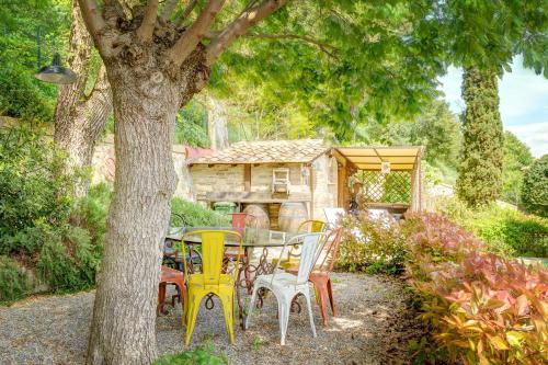a table and chairs under a tree in a yard at Garden House in Montepulciano
