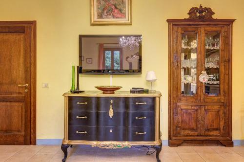 a dresser in a room with a mirror and a cabinet at Garden House in Montepulciano