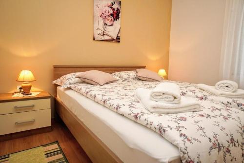 a bedroom with a bed with towels on it at Apartman Dea in Crveni Vrh