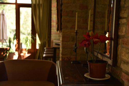 a vase with flowers on a table in a room at Mont Helmos Hotel in Klitoria