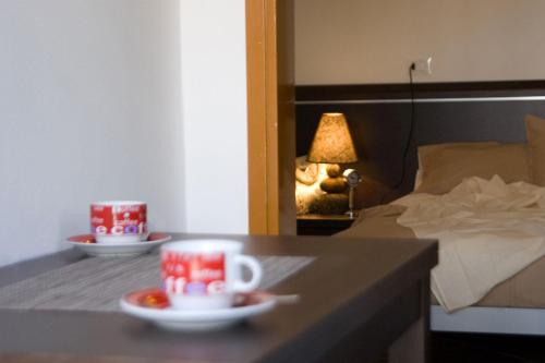 ビビオーネにあるCasa Augustaのベッド、テーブル、コーヒーカップが備わる客室です。