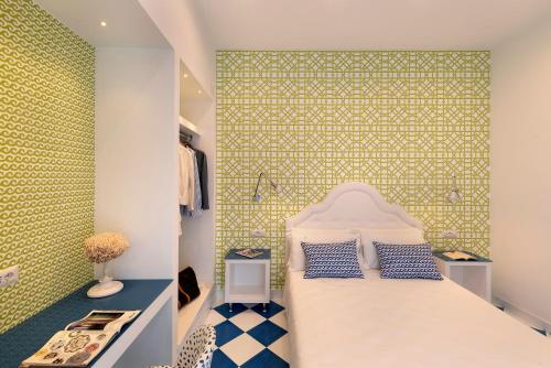 1 dormitorio con cama y pared verde en Design Holiday Home in Sorrento city center, en Sorrento