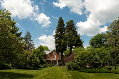 a house on a lawn with trees at South Court Inn in Luray