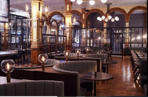 a restaurant with tables and chairs in a building at Beautiful 4 bedroom Victorian Apartment Sleeps 7 STOCKPORT in Manchester
