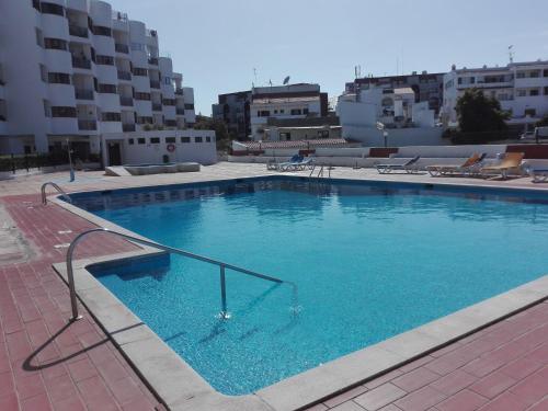 uma grande piscina com água azul num edifício em Edificio Coral em Albufeira