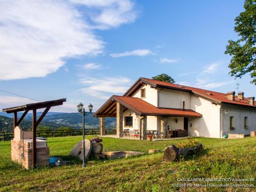 a house on a hill with a green field at Il Casolare Bioenergetico in Albareto