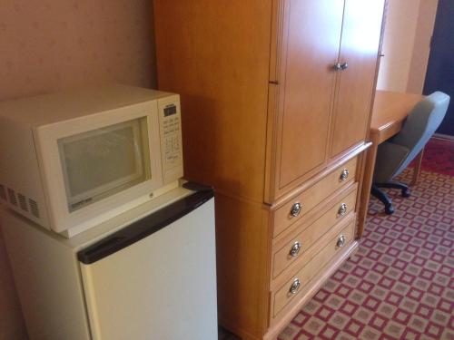a microwave on top of a refrigerator next to a cabinet at Stardust Motel in Naperville