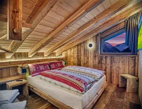 1 dormitorio con 1 cama en una cabaña de madera en Le Chalet Luxury Apartment, en Livigno