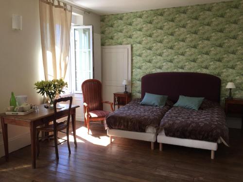 1 dormitorio con cama, escritorio y mesa con sillas en L'Aventure, en Châteauneuf-sur-Loire