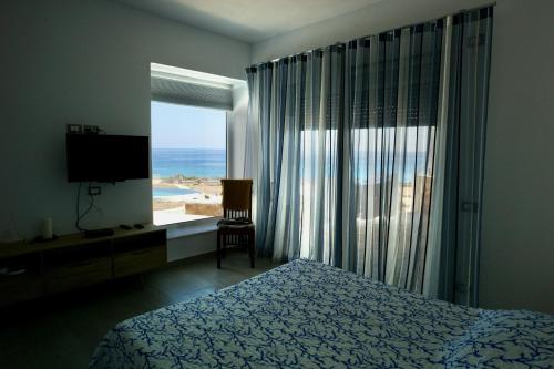a bedroom with a bed and a view of the ocean at Villa Chelidonia in Karpathos