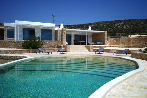 a swimming pool in front of a house at Villa Chelidonia in Karpathos