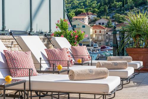 a row of lounge chairs on a balcony with a view at Heritage Hotel Tisno in Tisno