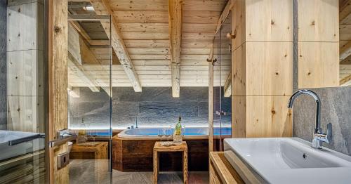 a large bathroom with a tub and a sink at Le Chalet Luxury Apartment in Livigno