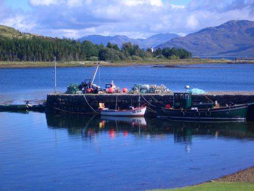 two boats are docked at a dock in the water at Hotel Eilean Iarmain in Isleornsay