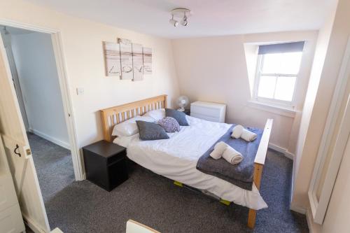 a bedroom with a bed with pillows on it at Ocean Apartment, 50 yds to Beach, Sleeps 10 in Weymouth