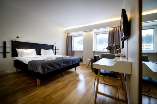 a hotel room with a bed and a desk and a chair at Hotell Alfred Nobel in Karlskoga