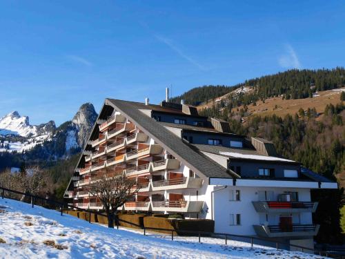 a building in the mountains with snow on the ground at Romantic Chalet-Style Flat with Mountain View in Torgon