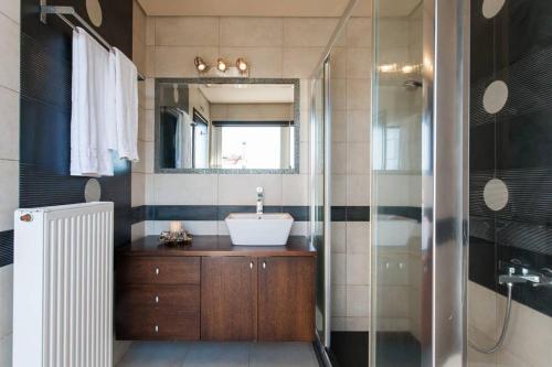 a bathroom with a sink and a shower at Unique Villa Melia Lagonisi in Kalívia Thorikoú