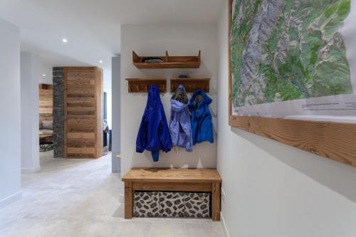 un couloir avec des vestes bleues suspendues sur un mur dans l'établissement Apartment Brevent Fodera, à Chamonix-Mont-Blanc