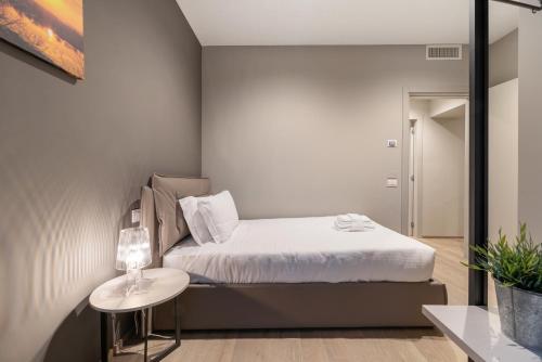 a small bedroom with a bed and a table at JOIVY Treviso Vittoria in Treviso