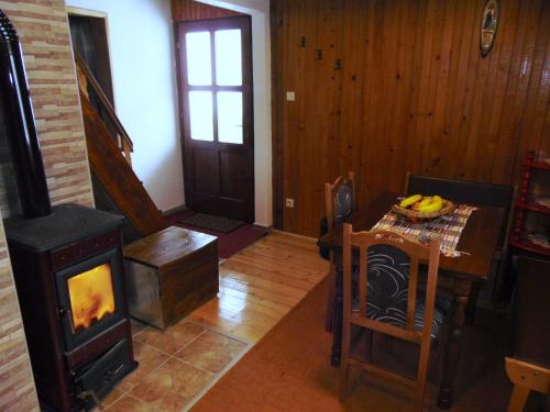 a living room with a wood stove and a table at Vikendica Sekulić in Bajina Bašta