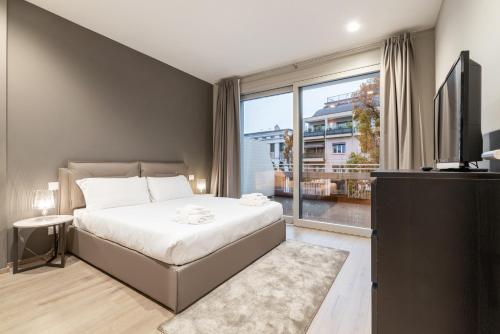 a bedroom with a bed and a large window at JOIVY Treviso Vittoria in Treviso