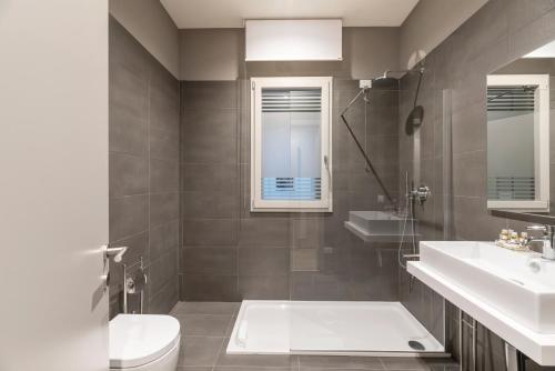 a bathroom with a tub and a sink and a toilet at JOIVY Treviso Vittoria in Treviso