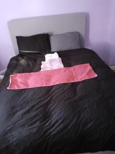 Una cama negra con una sábana rosa. en Double Room in Honiton House, en Hendon