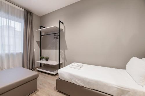 a white room with two beds and a mirror at JOIVY Treviso Vittoria in Treviso