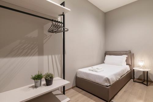 a small bedroom with a bed and a table at JOIVY Treviso Vittoria in Treviso