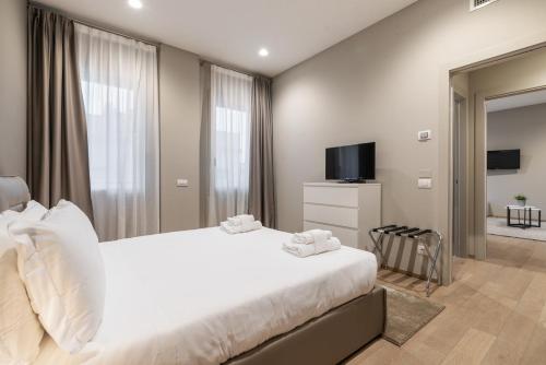 a bedroom with a large bed and a television at JOIVY Treviso Vittoria in Treviso