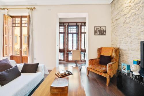 a living room with a white couch and a chair at Bennecke Bailen in Alicante