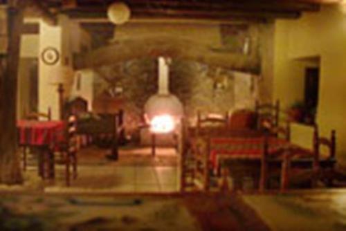 a room with a table and a fire in a fireplace at Los Jerónimos in La Tuda