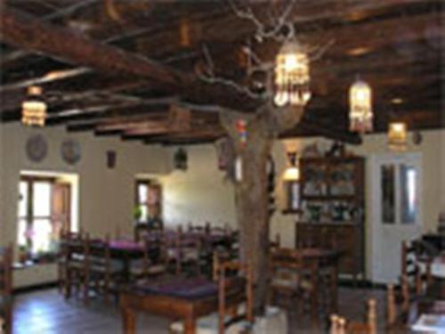 Habitación con mesas, sillas y techo de madera. en Los Jerónimos, en La Tuda