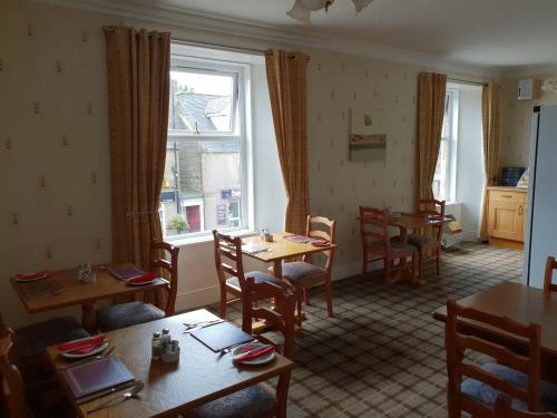 a dining room with tables and chairs and a window at Commercial Hotel in Alness