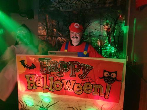 a man is standing behind a happy halloween sign at Commercial Hotel in Alness